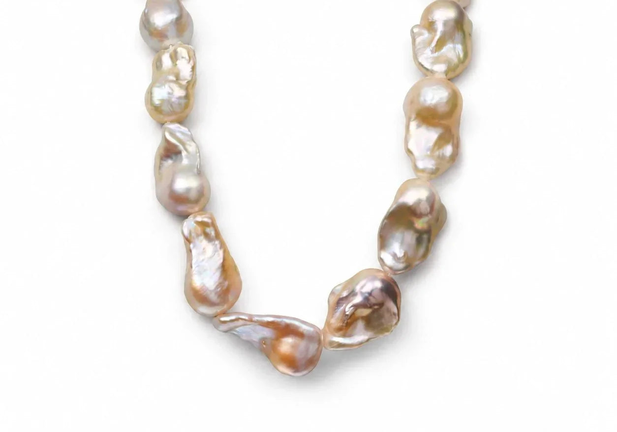 Elysian golden baroque pearl necklace arranged as a full strand on a light gray background