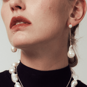 Minimalist dangling pearl earrings in 18k gold, a sculptural statement piece