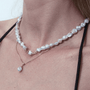 Model styling pearl pendant for everyday quiet luxury outfit