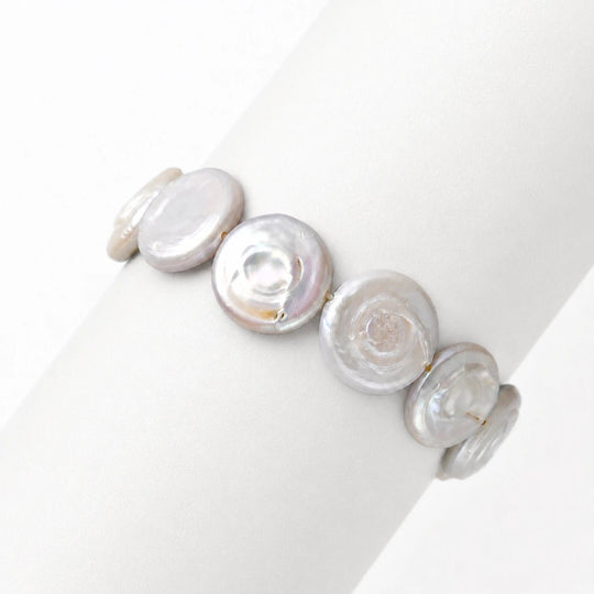 Clean white studio shot of coin button baroque pearl bracelet, smooth luminous flat round white freshwater baroque pearls 