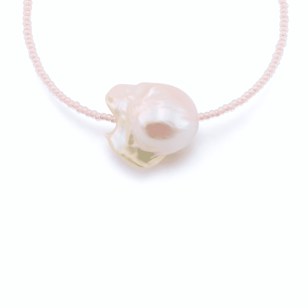 Close-up of large baroque pearl detail on pink beaded bracelet