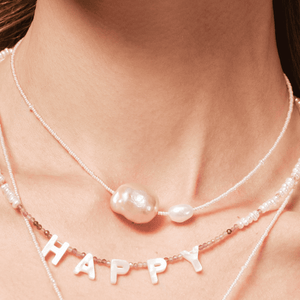 Close-up of two-tone baroque pearls on pink beaded necklace