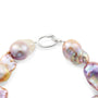 Close-up white background product shot of silver lobster spring ring clasp connected to strand of oversized organic purple freshwater baroque pearl beads