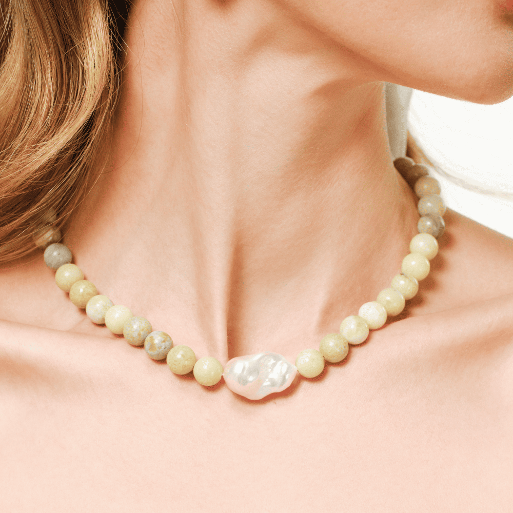 Close up of grand baroque pearl centrepiece and green serpentine beads on model