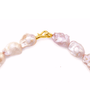 Close up of irregular pink freshwater baroque pearls and gold S clasp detail