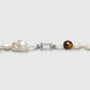 Close up of natural uncarved white keshi baroque pearls, striped tiger eye beads and silver clasp 