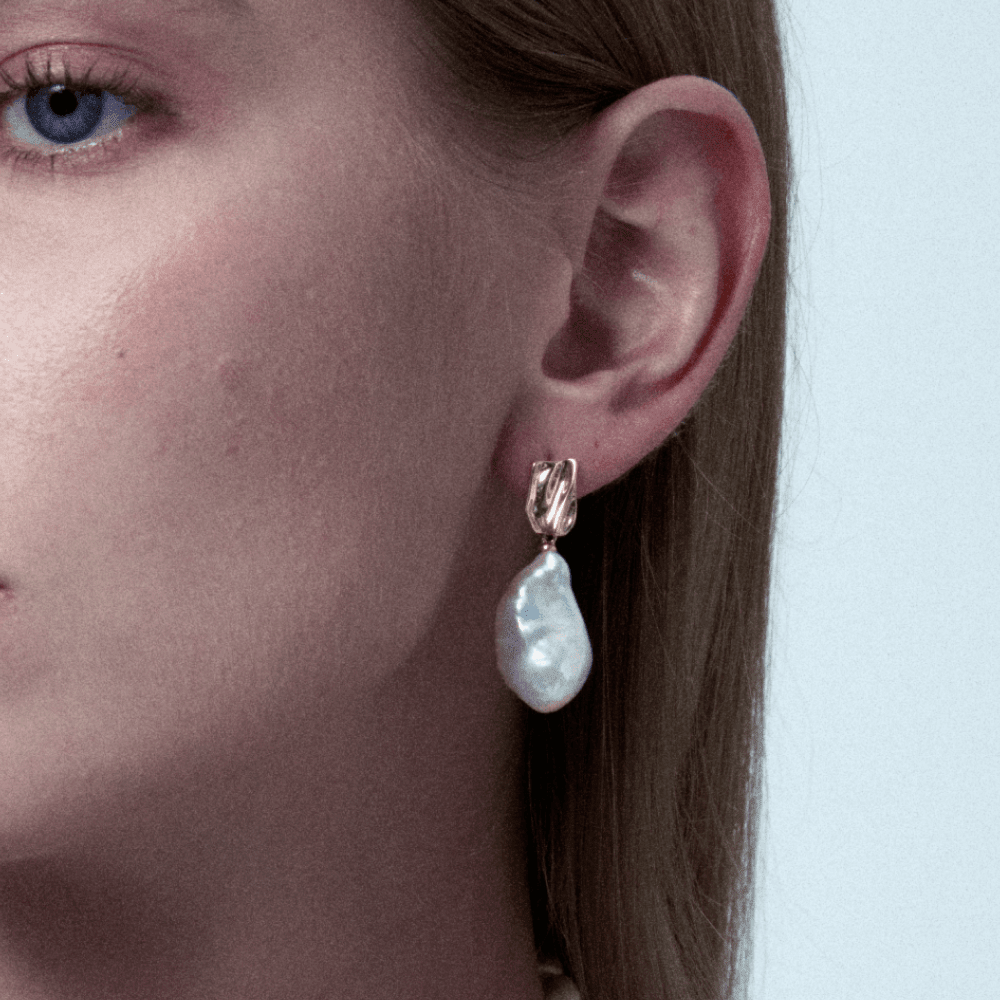 Model wearing flowing freshwater pearl drop earrings, ideal for ethereal date night looks for women.