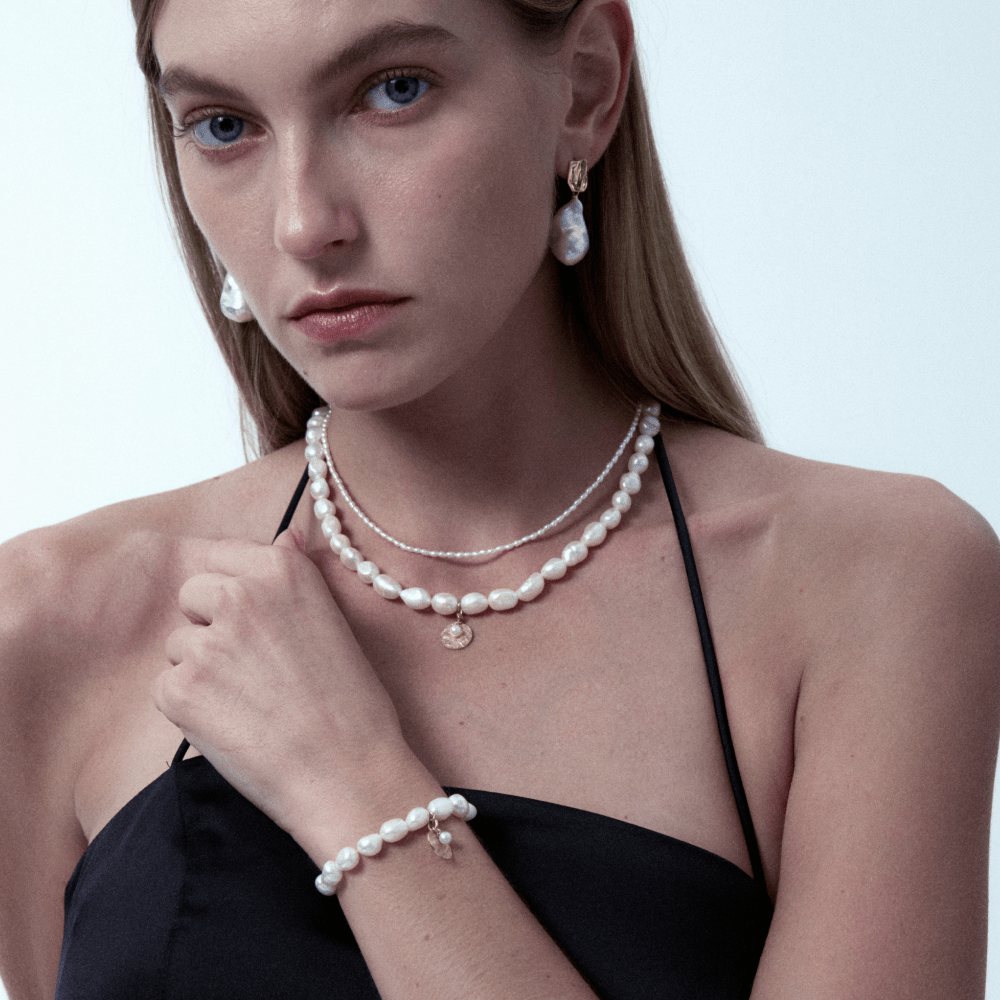 Model styling the pearl bracelet with matching pearl necklace