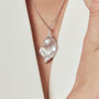 Model wearing gray pearl pendant with white blazer