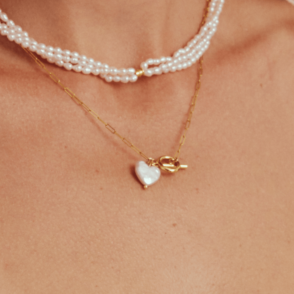 Layered necklace look with a heart on chain and toggle pendant, perfect for wedding jewelry or a romantic goth date night outfit.