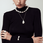 Detailed view of a model wearing a large natural pearl necklace with silver baroque accents and organic textures.