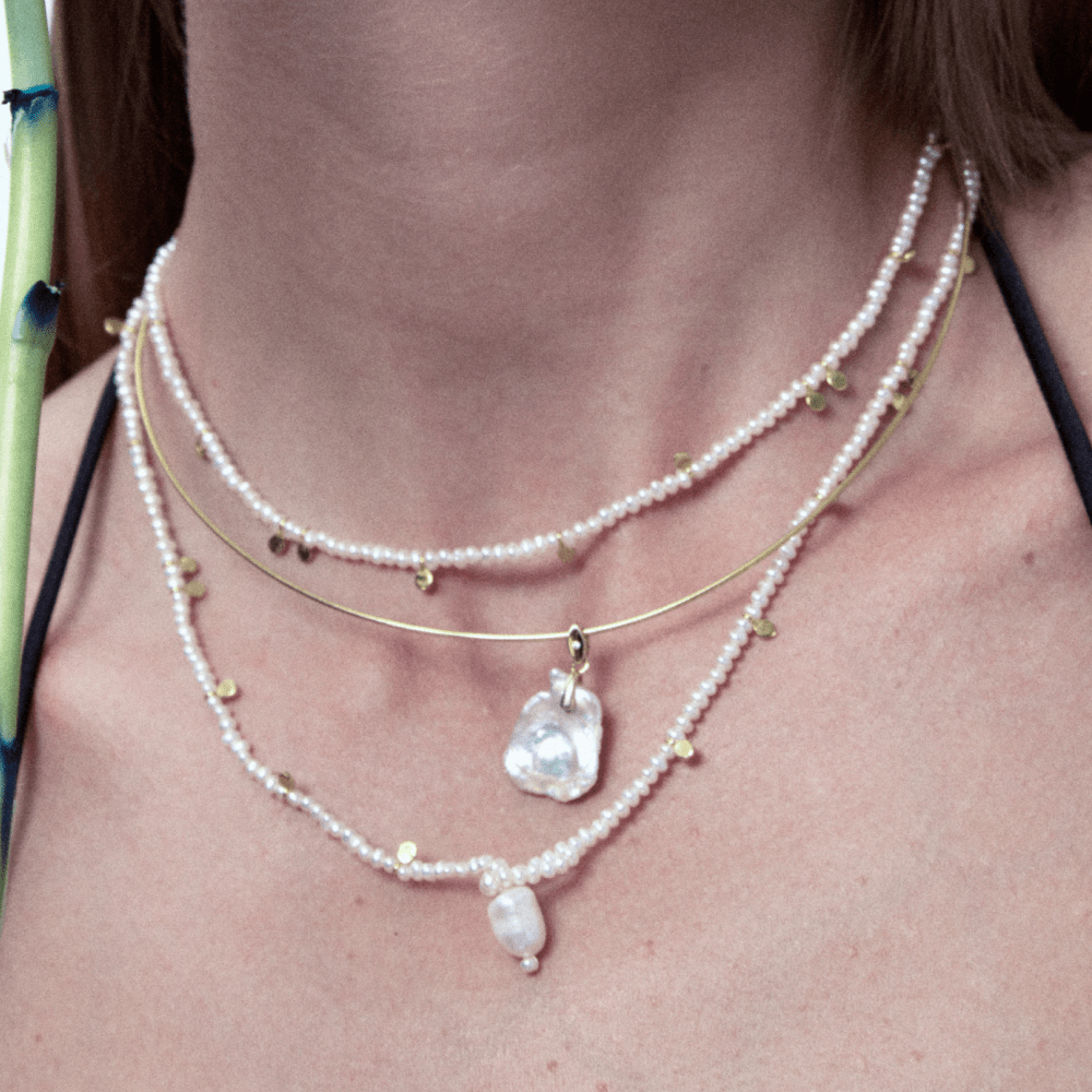 Layered Aurora baroque pearl necklace styled with other necklaces