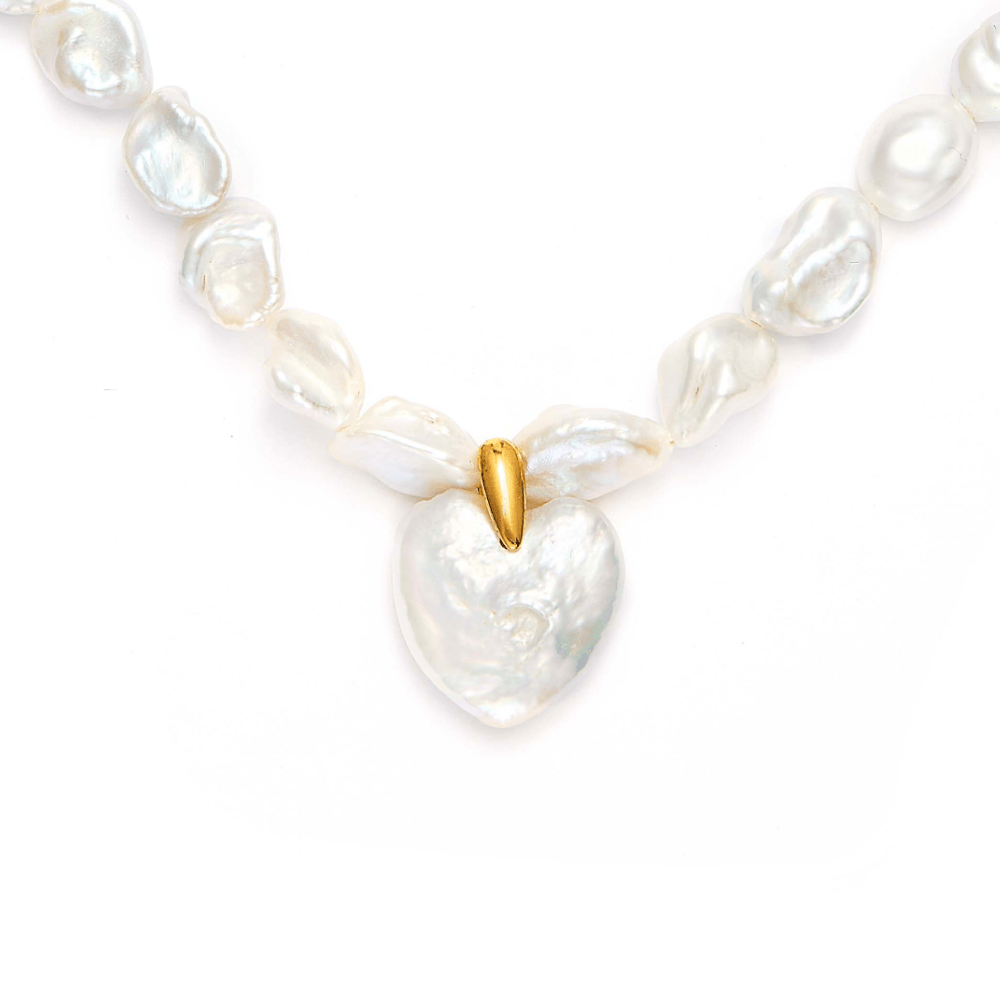 close-up look of heart shaped pearl necklace , ethereal bridal jewelry for weddings and special occasions.