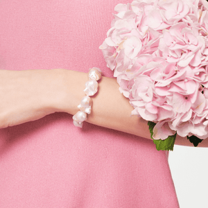 Model wearing baroque pearl bracelet with pink flower bouquet lifestyle shot