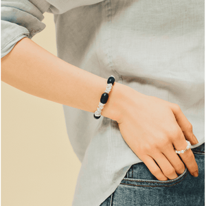 Model wearing lapis pearl bracelet stacked with other pearl ring