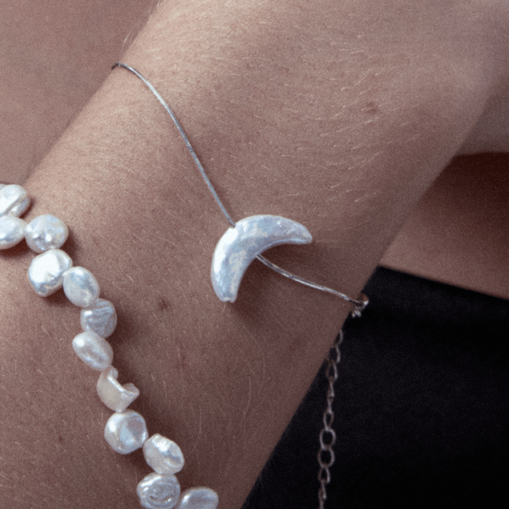 Model wearing the moon pearl bracelet with stacked jewelry
