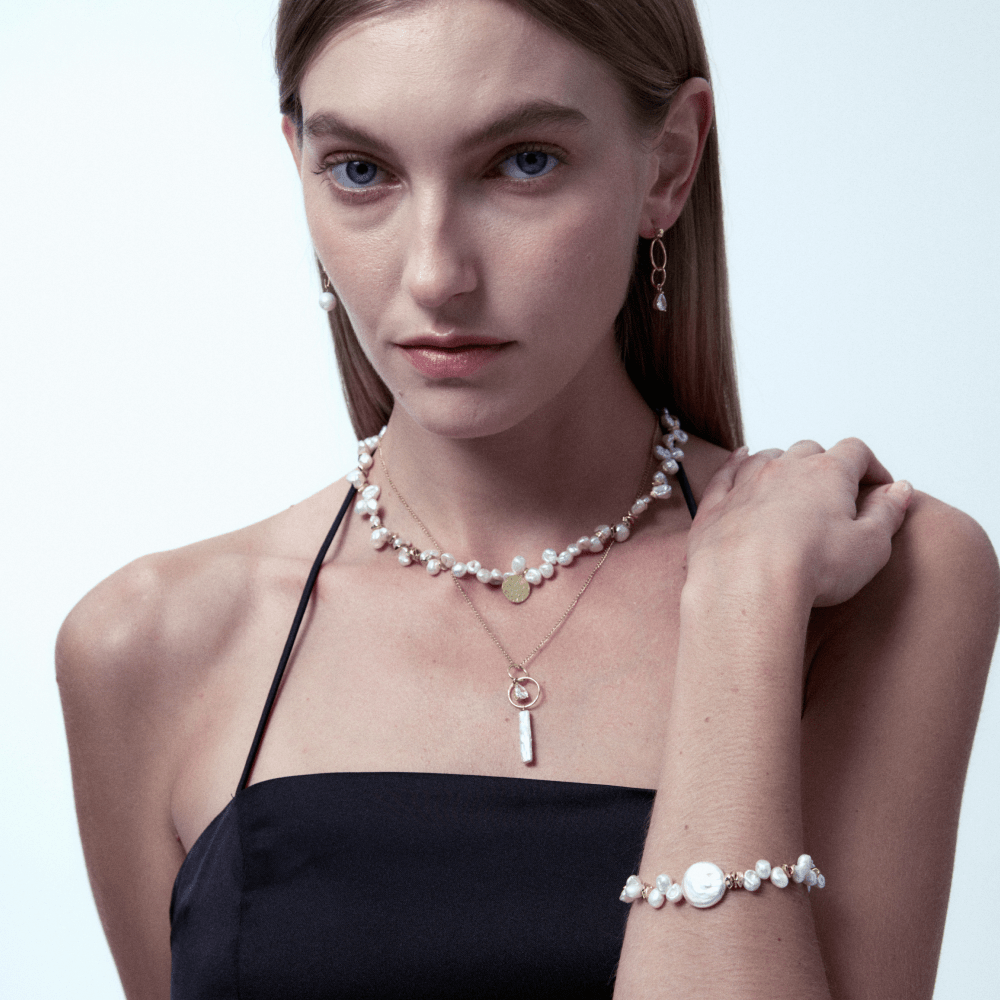 Model wearing pearl pendant necklace with elegant black formal dress