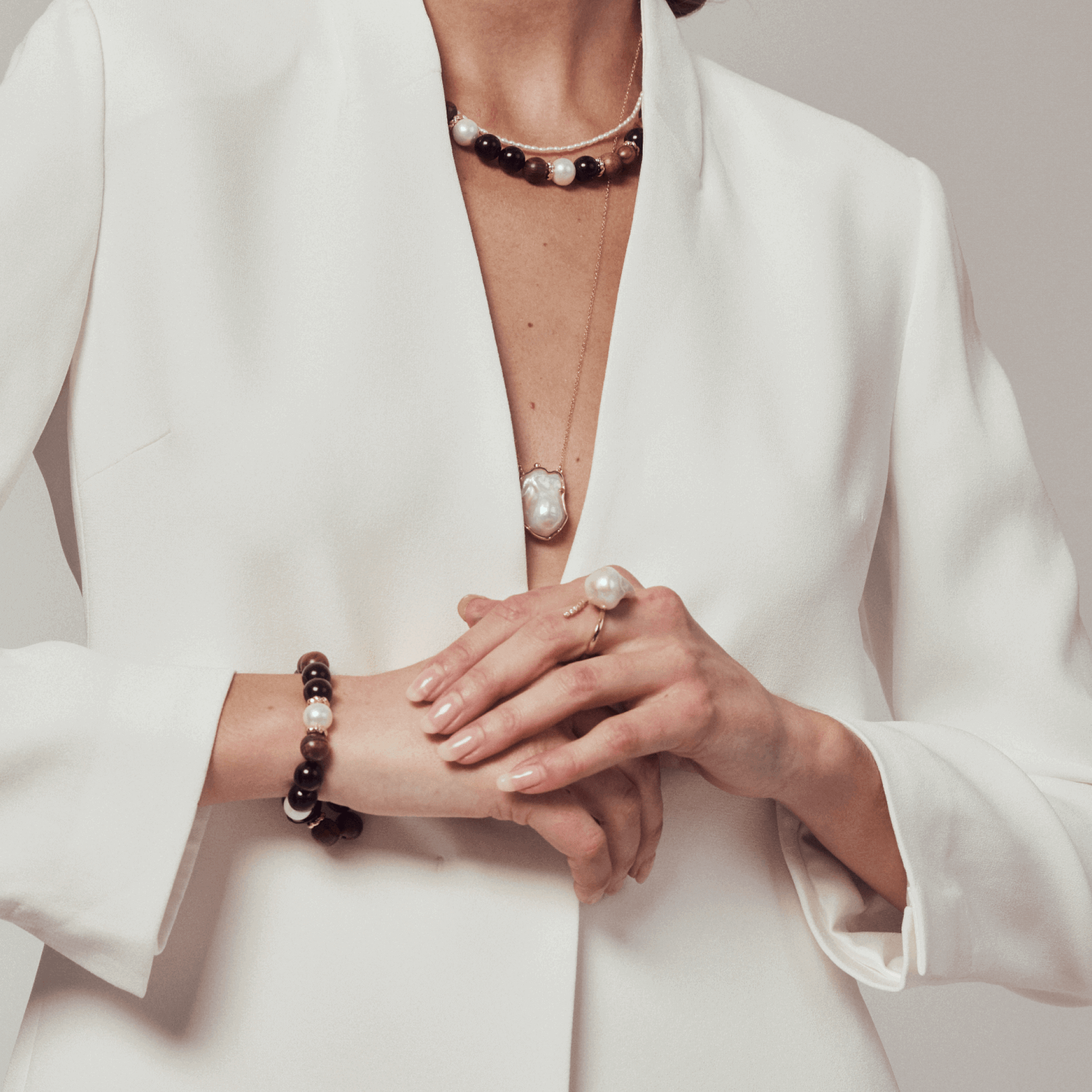 Model styling the pearl ring with white blazer for formal look