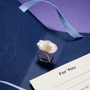 Baroque pearl ring styled on purple background with gift ribbon