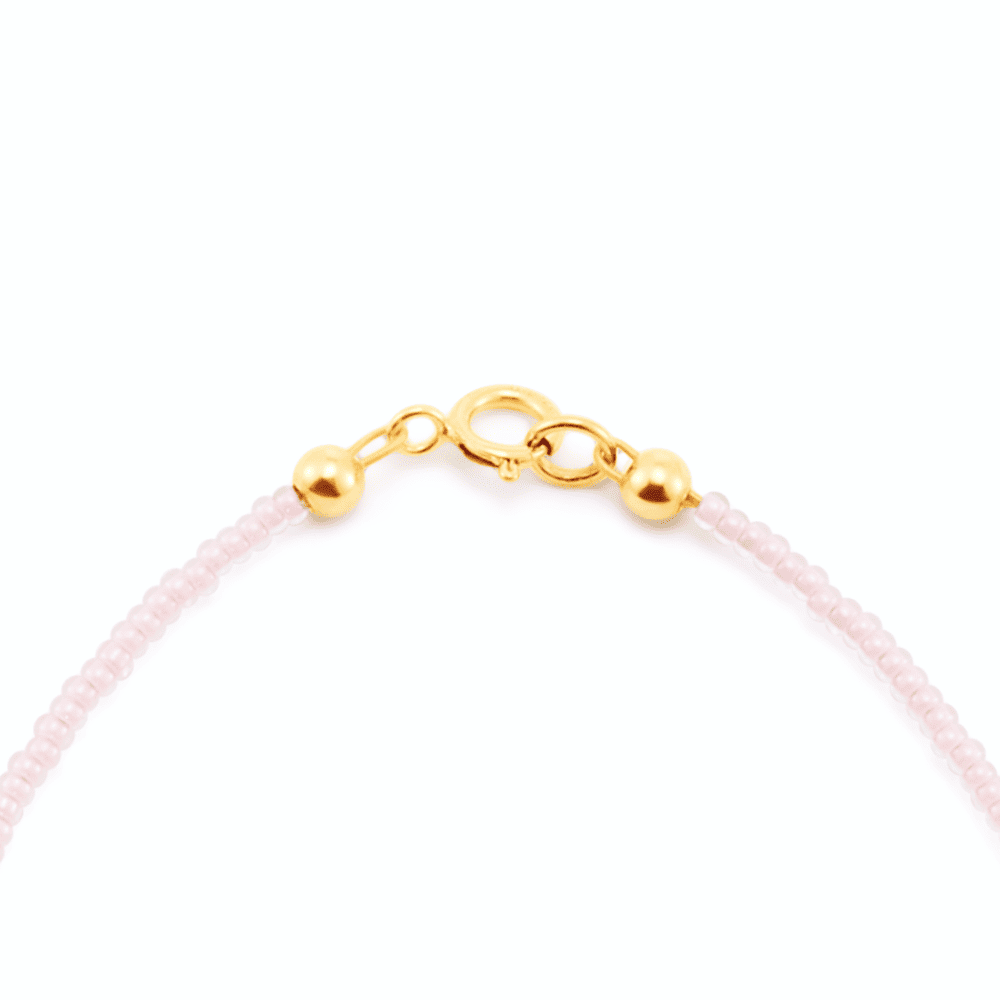 Polished 14k gold spring ring clasp detail of pink beaded pearl bracelet