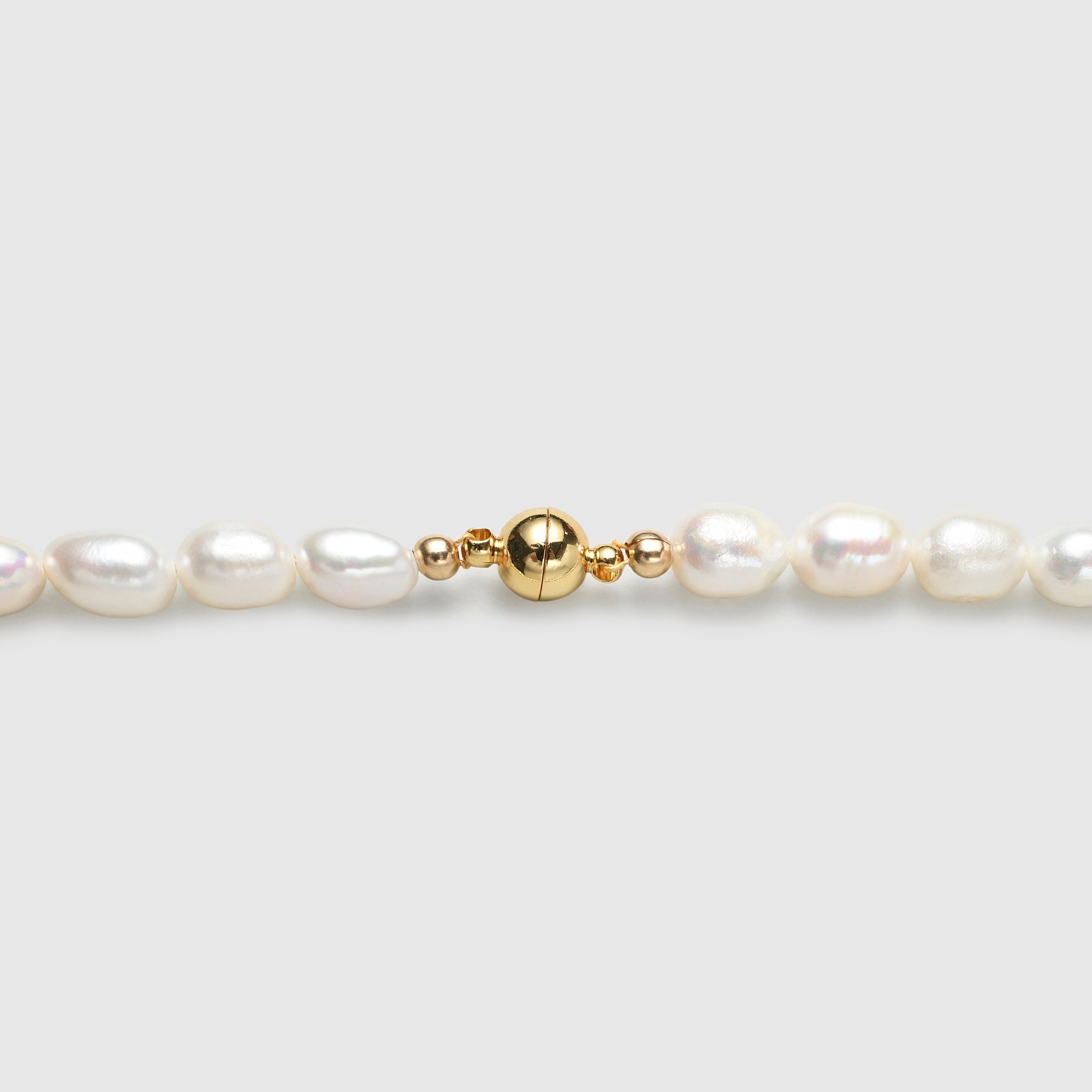 Polished gold clasp close up look on freshwater barouque pearl necklace