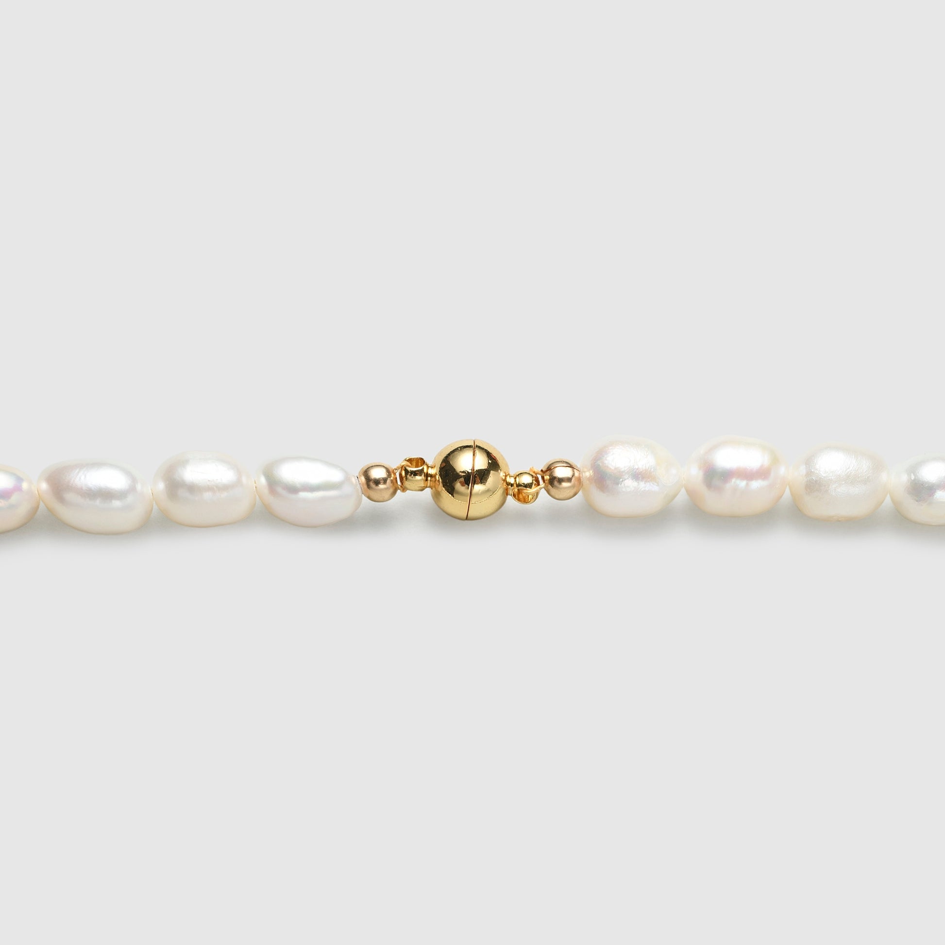 Polished gold clasp close up look on freshwater barouque pearl necklace