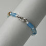 Neutral close-up highlighting unique blue green iridescent blue minerals, sterling silver s-hook
