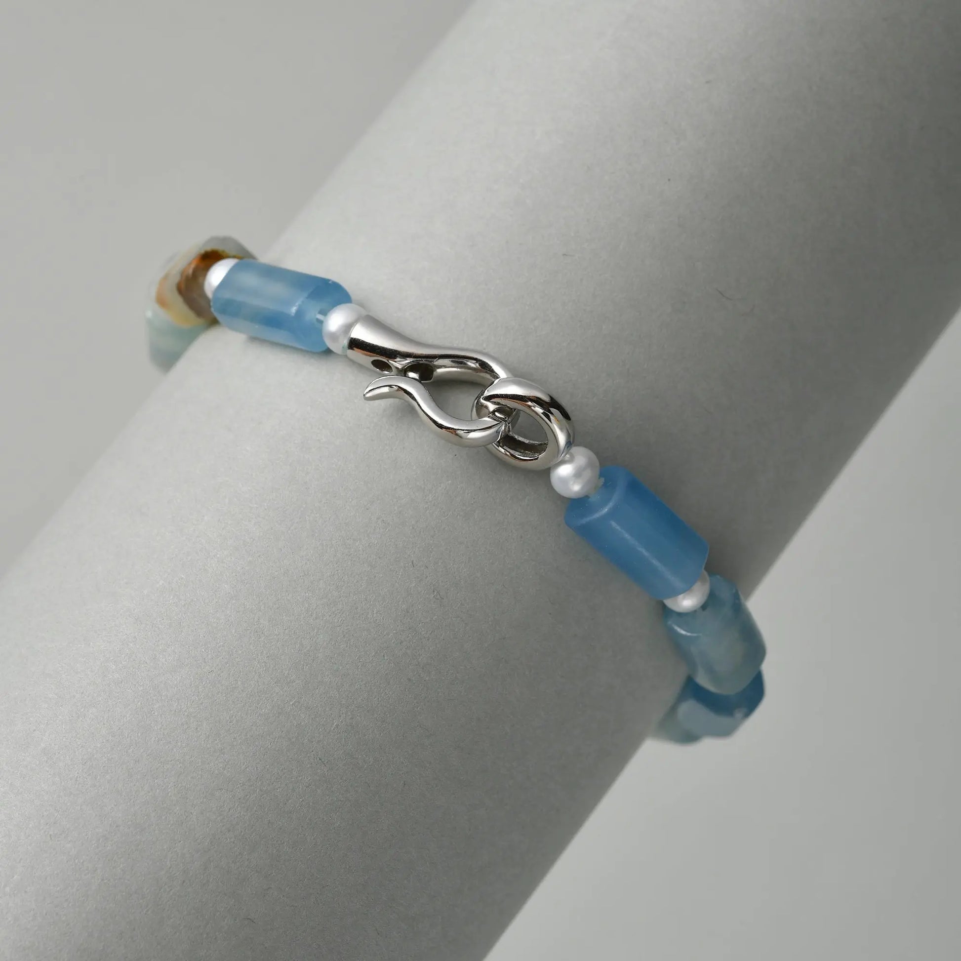 Neutral close-up highlighting unique blue green iridescent blue minerals, sterling silver s-hook