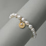 Side view of the button pearl bracelet with gold charm