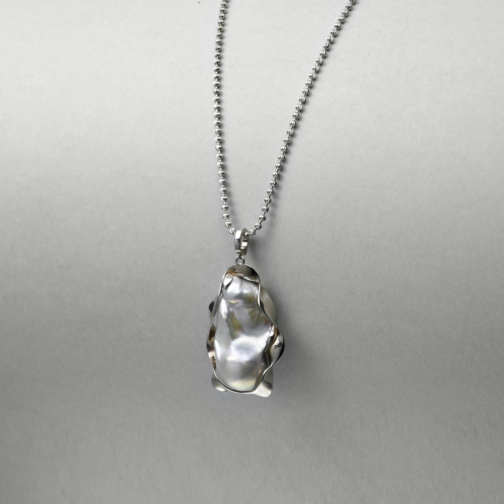 close-up-of-gray-baroque-pearl-with-silver-frame-setting-organic-curves