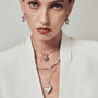 Model styling the pearl necklace with formal layered jewelry