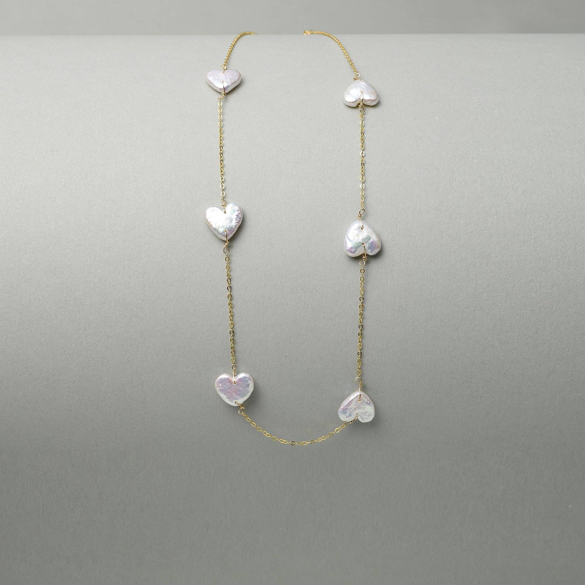 Heart shaped pearl necklace with a romantic vibe, a versatile piece for music festival outfits and summer holiday styling.