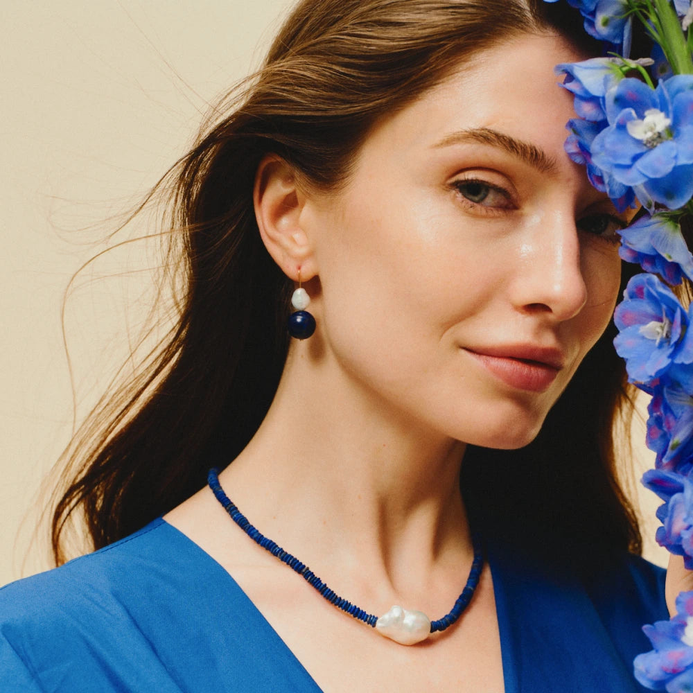 Woman wearing the Coral baroque pearl and lapis lazuli drop earrings on her ears