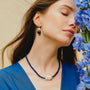 Woman wearing the Coral baroque pearl and lapis lazuli jewelry set necklace and earrings