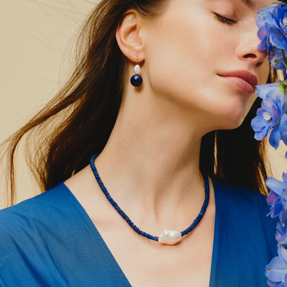 Woman wearing the Coral baroque pearl and lapis lazuli necklace around her neck