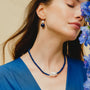 Woman wearing the Coral baroque pearl and lapis lazuli necklace around her neck