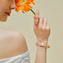 Woman wearing the Soleil golden baroque pearl bracelet on her wrist