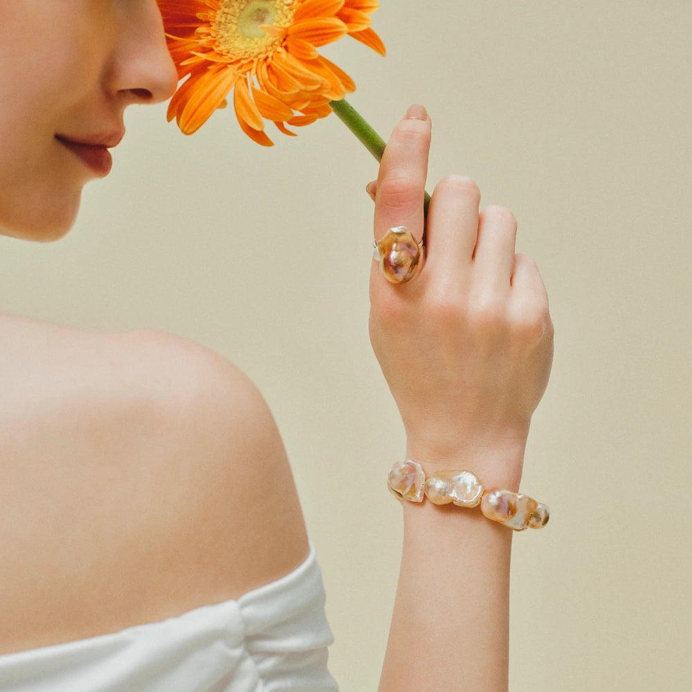 Woman wearing the Soleil golden baroque pearl bracelet on her wrist