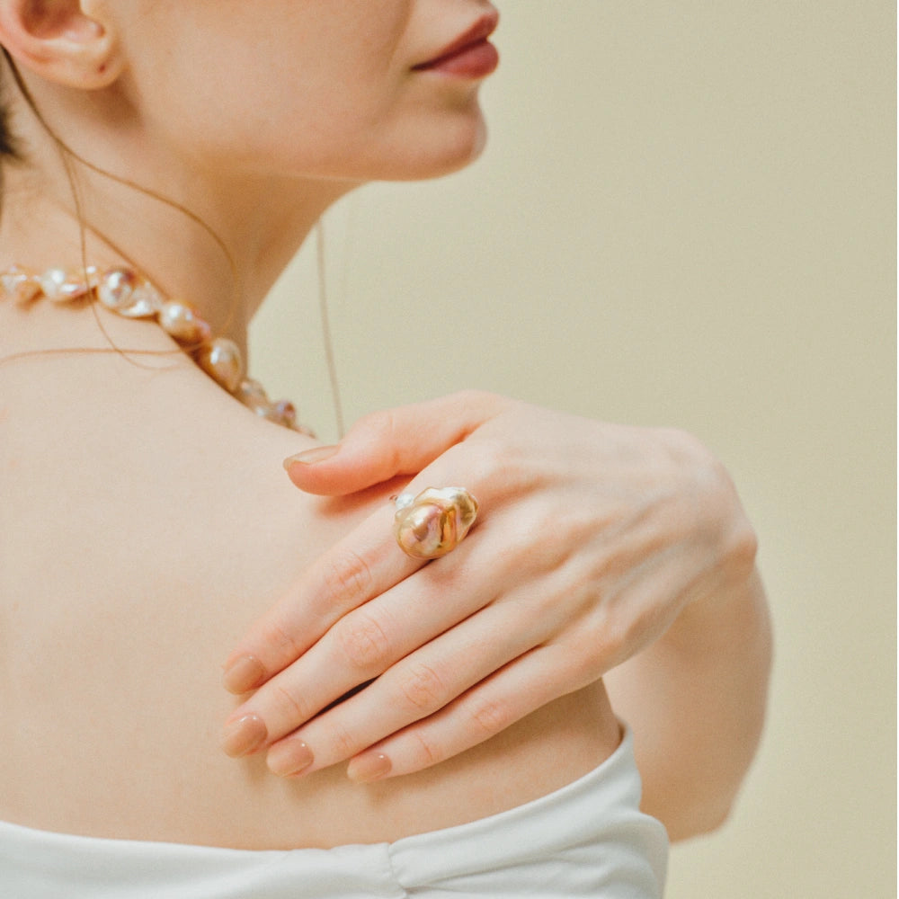 Woman wearing the Soleil golden baroque pearl open ring on her finger