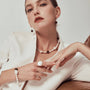 Woman wearing the Tigo white oval baroque pearl tiger eye drop earrings