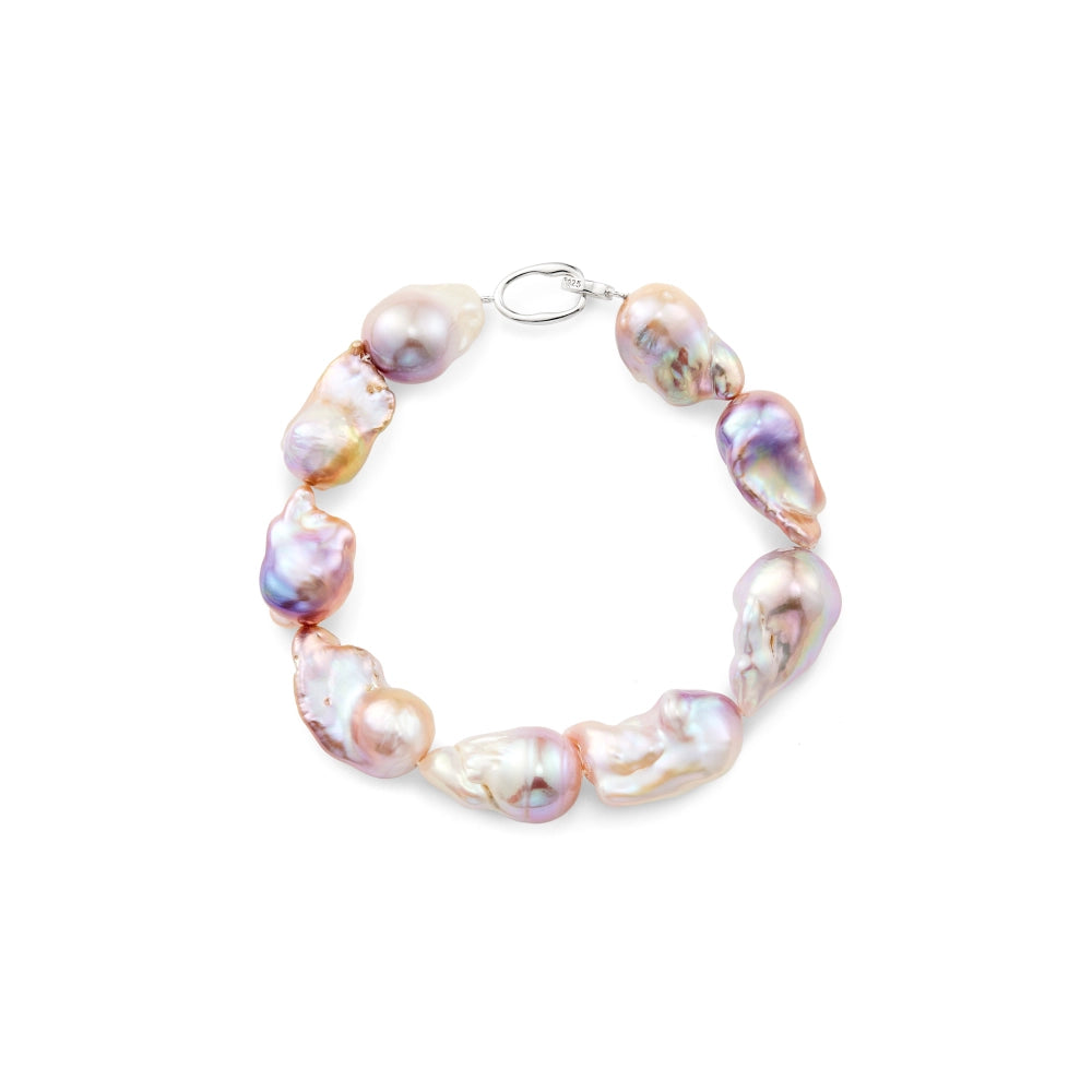 Top-down flat studio shot of silver beaded bracelet strand, strung with large luminous iridescent purple irregular freshwater baroque pearls and silver lobster clasp on plain white background