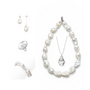 Minimal white flat lay of Imogen all-white baroque pearl sterling silver 5-piece stacking set, asymmetrical drop mismatched pearl earrings, open pearl ring, curved pearl bracelet, large irregular pearl choker & thin silver pendant necklace