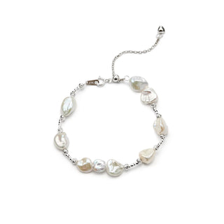 product shot of thin sterling silver bracelet strung with natural mini irregular white keshi pearls, fitted with lobster clasp and adjustable extender chain on white background